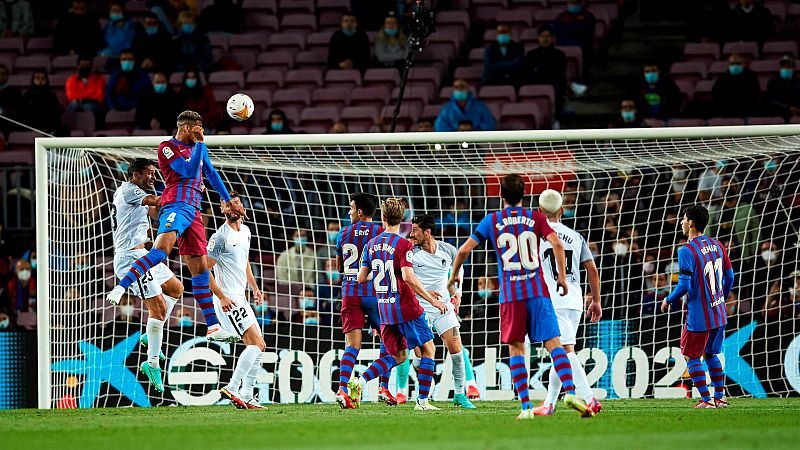 El defensa uruguayo del FC Barcelona Ronald Araújo (elevado sobre el resto, 2º por la izqda) remata de cabeza ante el Granada