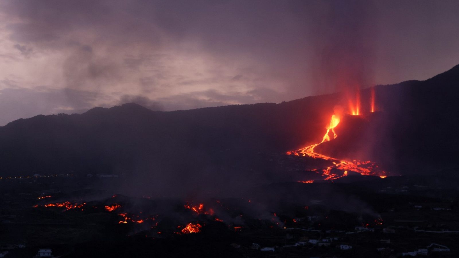 La lava flueix i el fum s'eleva durant l'albada després de l'erupció d'un volcà a l'illa de La Palma, a Todoque