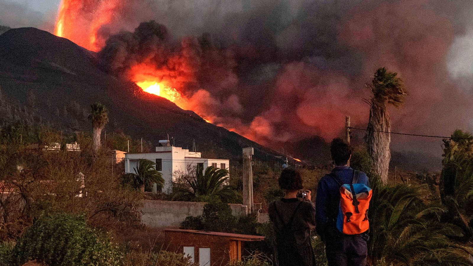 Dos personas observan la erupción volcánica de Cumbre Vieja, en la isla de La Palma.