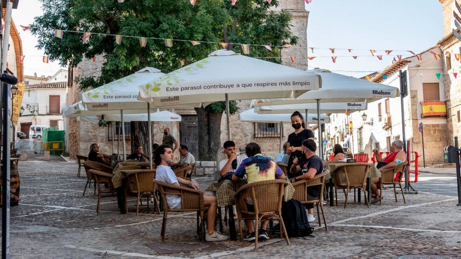 Varias personas en la terraza de un bar en España. 