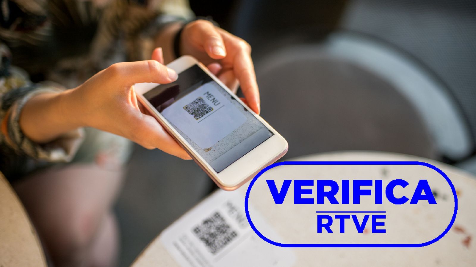 Imagen de un dispositivo móvil escaneando un código QR, con el sello azul de VerificaRTVE