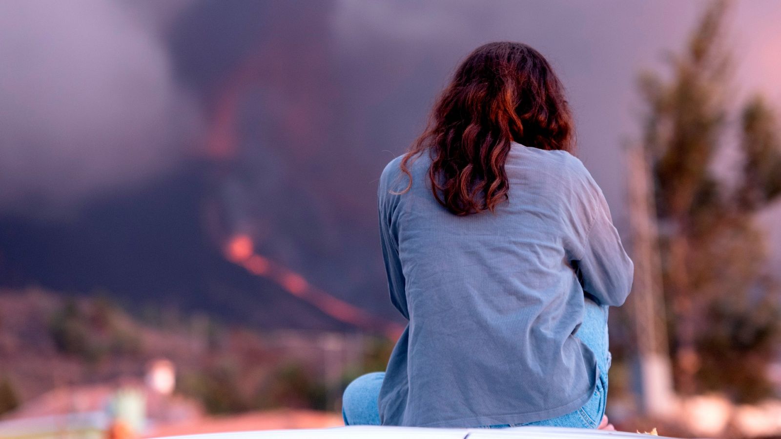 Una mujer observa el volcán de La Palma.