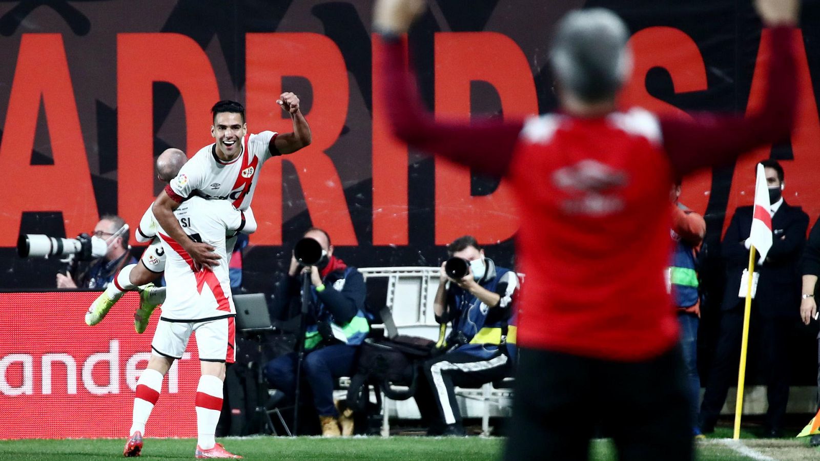 Isi aúpa a Falcao (al fondo) y un técnico levanta los brazos (desenfocado en primer término) para celebrar el gol del Rayo al Barça