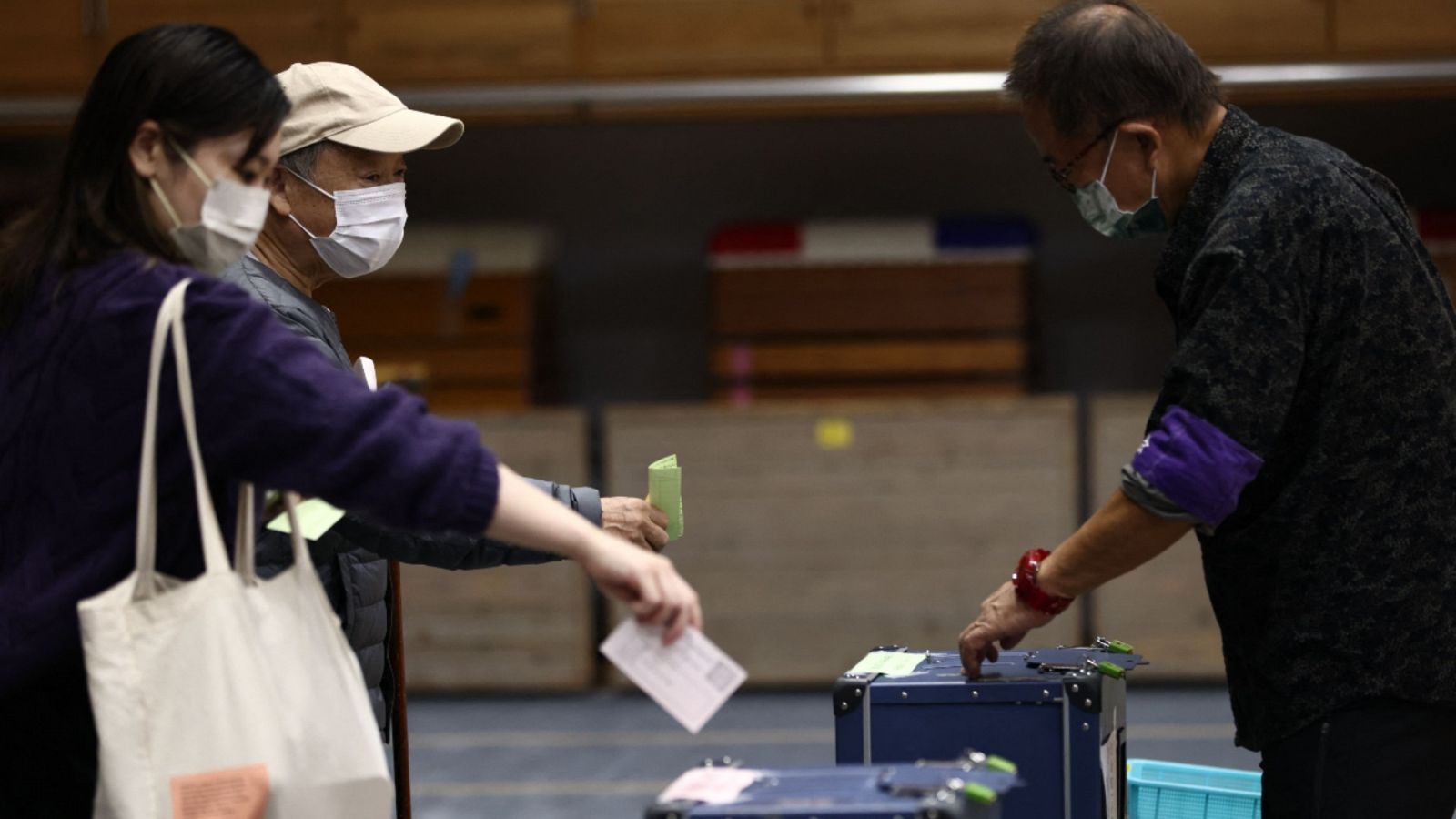 Imagen de dos personas votando en un colegio electoral en Tokio, Japón.