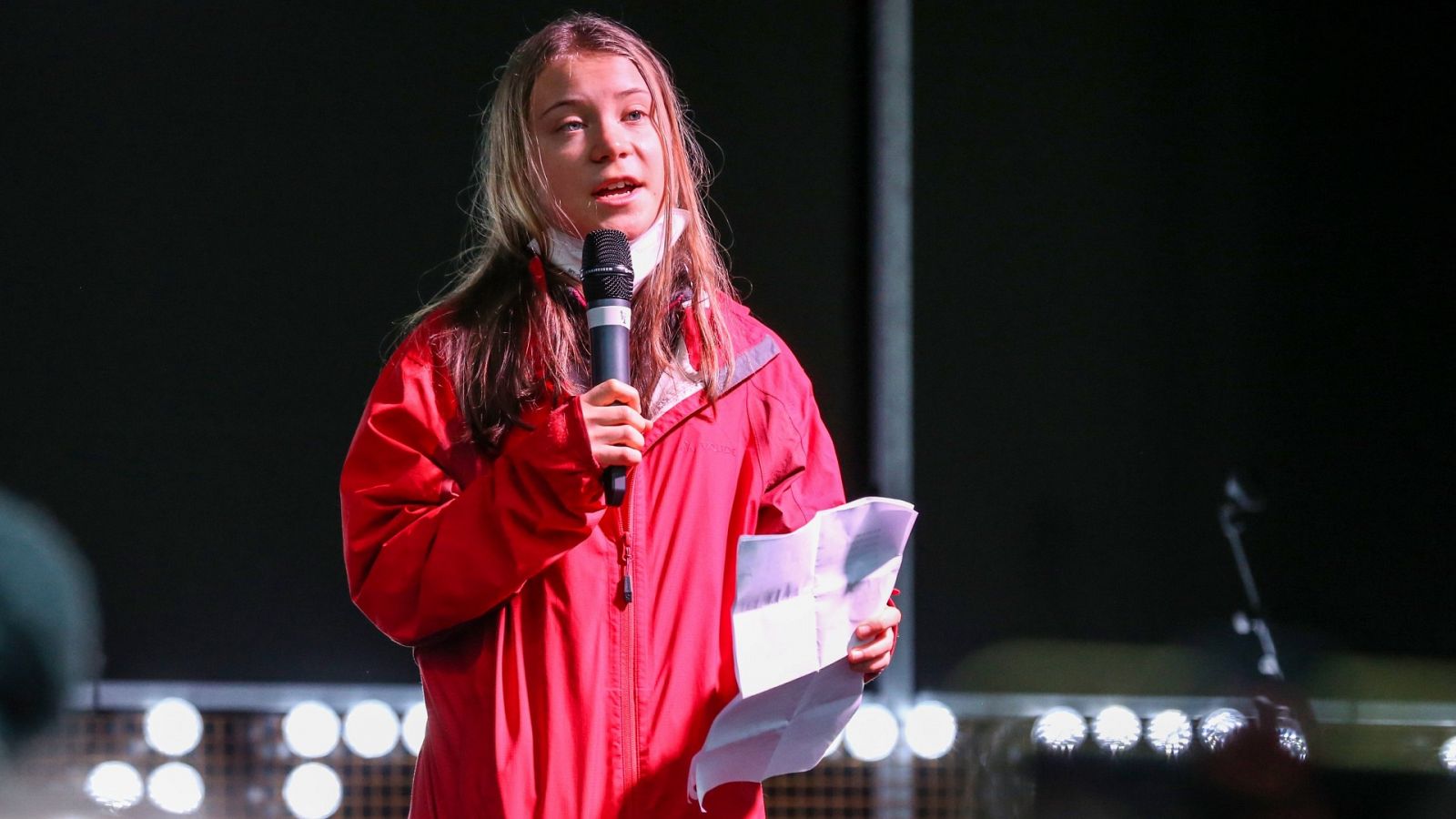 Greta Thunberg sostiene un micrófono mientras se dirige al público