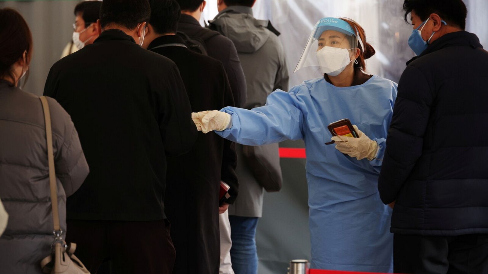 Una trabajadora sanitaria dirige a un grupo de personas para un tests de coronavirus en Seúl, Corea del Sur. REUTERS/Kim Hong-Ji