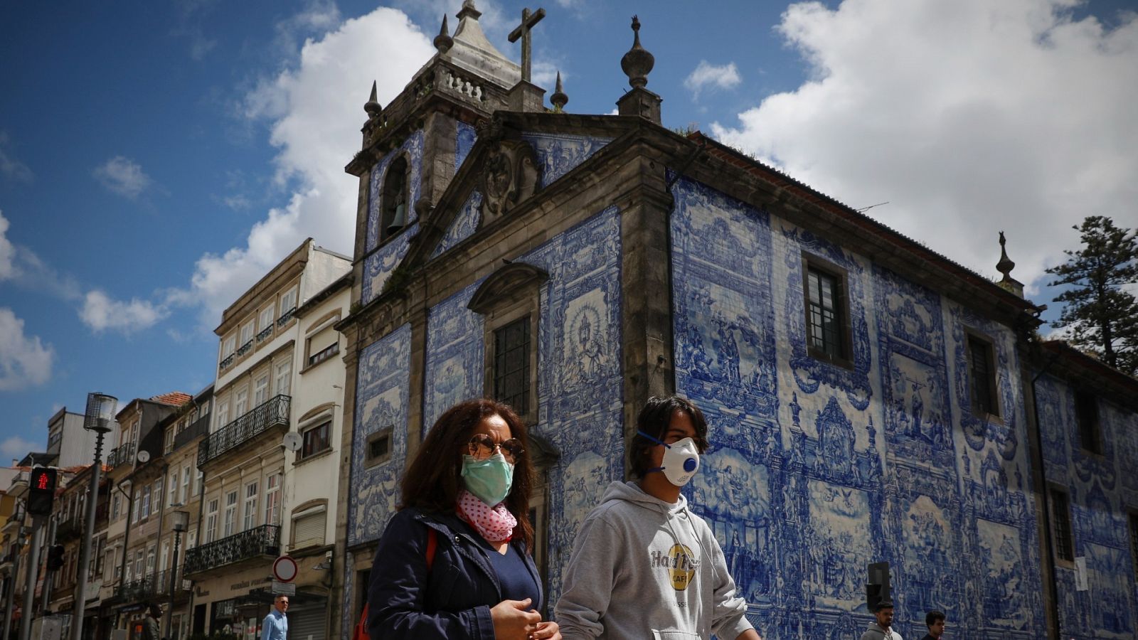 Dos personas pasan delante de una iglesia de Oporto, Portugal