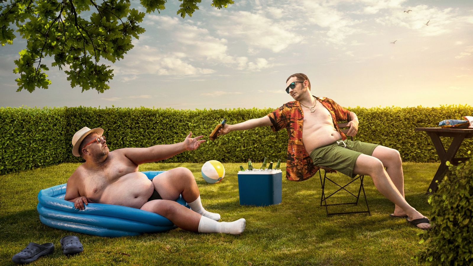 Dos hombres con apariencia extraña simulan en un jardín la postra del cuadro de la Creación de la Capilla Sixtina en bañador