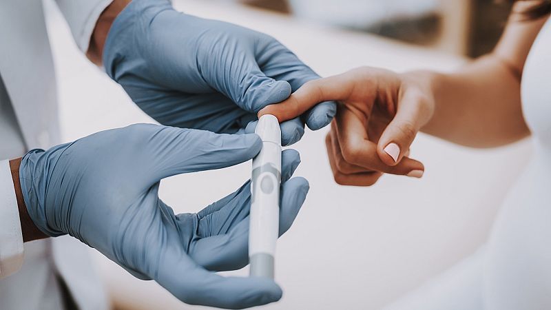 Un médico le mide el azúcar a un paciente