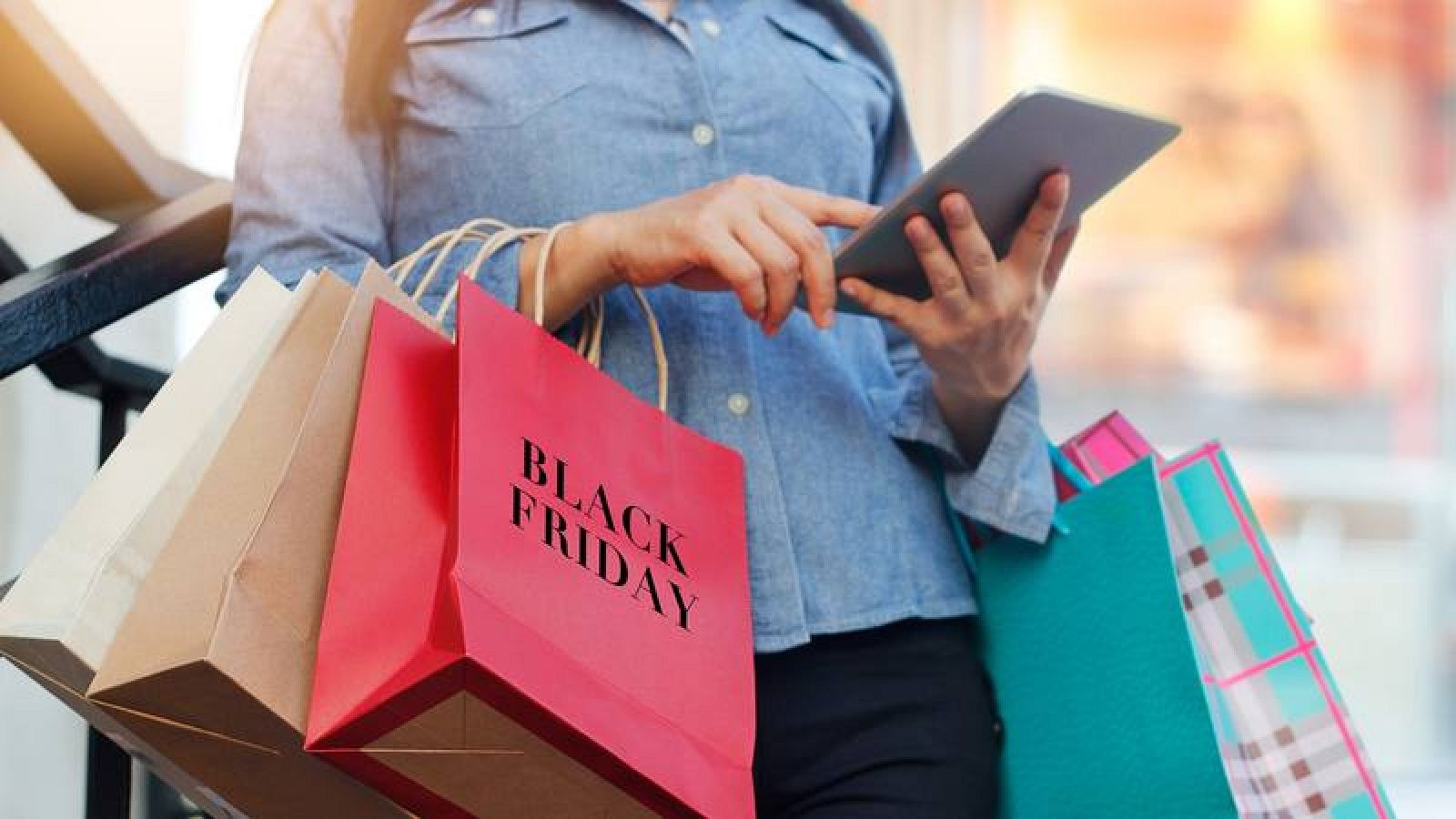 Una mujer consulta una tableta mientras compra en el Black Friday
