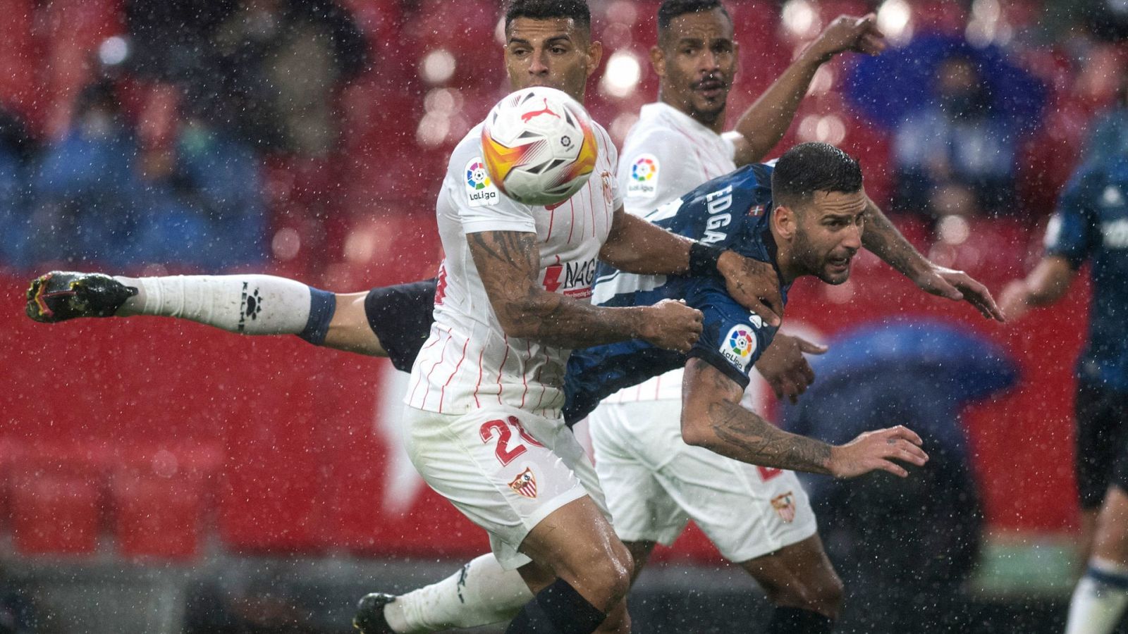 Edgar Méndez cae entre dos jugadores del Sevilla