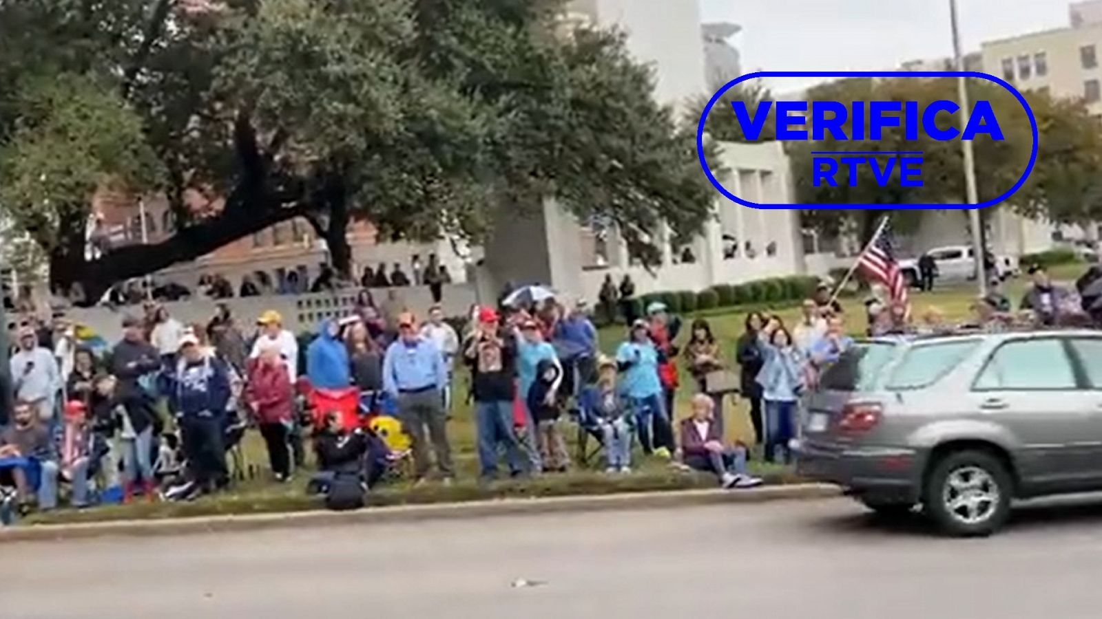 Imagen de seguidores de QAnon en Dallas esperando la vuelta de JFK Junior, con el sello azul de VerificaRTVE