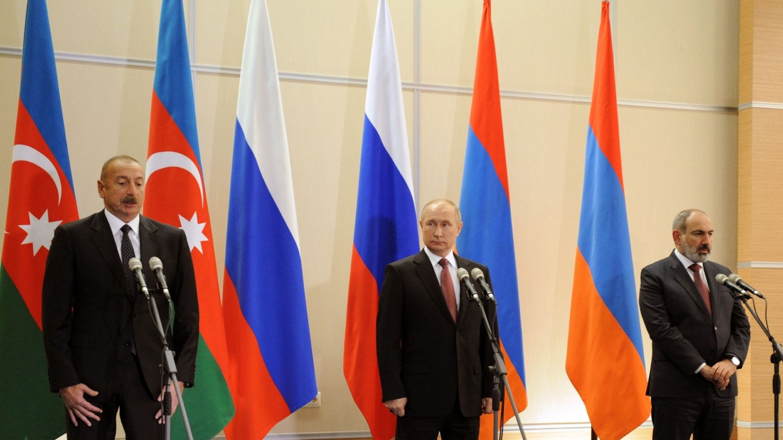 Ilham Aliyev, Vladimir Putin y Nikol Pashinyan posan delante de las banderas