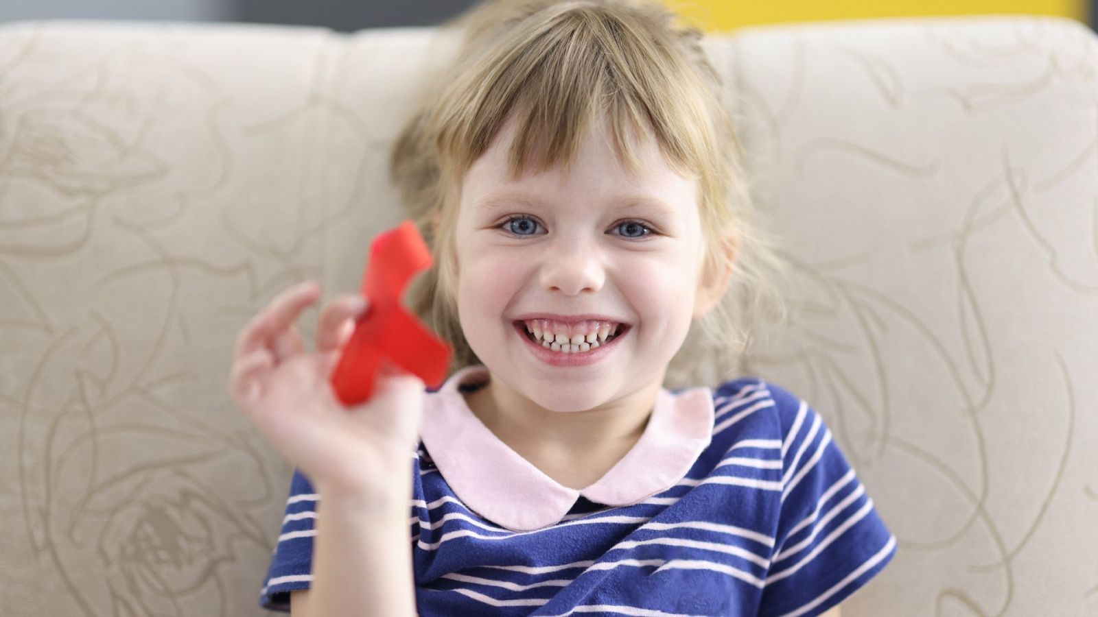 Niña sostiene cinta roja