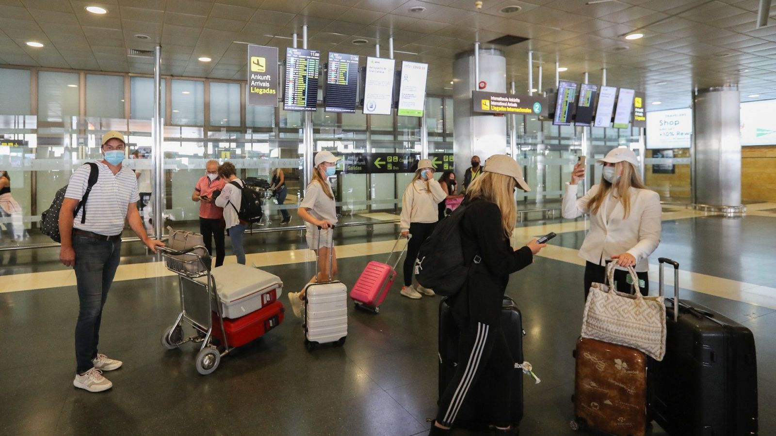 Varios turistas esperan este domingo en la terminal de llegadas del aeropuerto de Gran Canaria