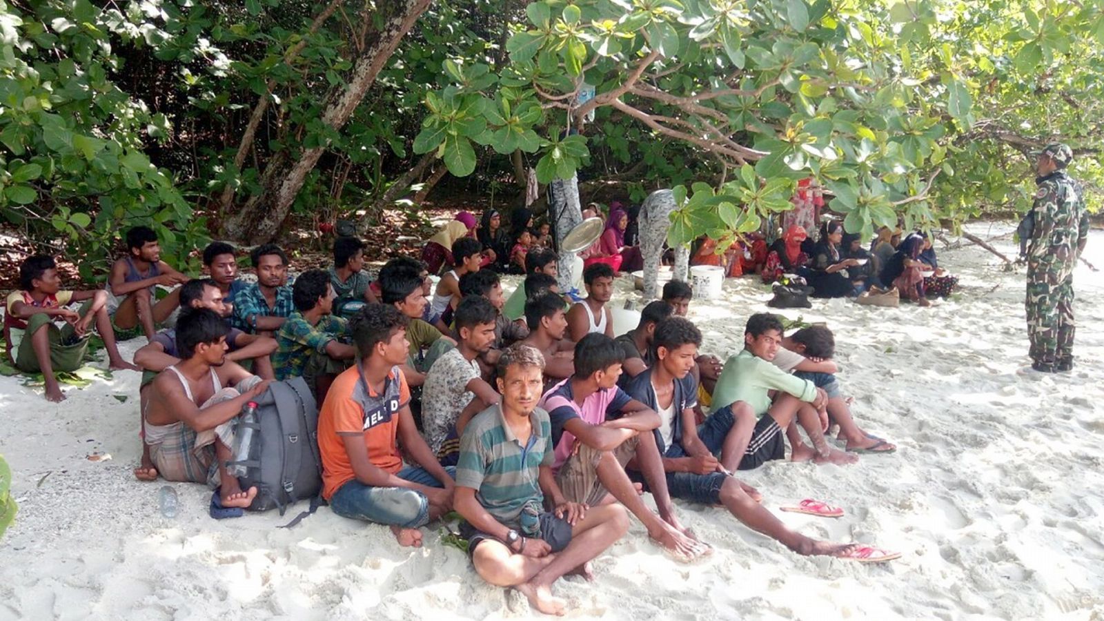 Miembros de las fuerzas tailandesas vigilan a un grupo de refugiados rohinyás en una playa al sur de Tailandia