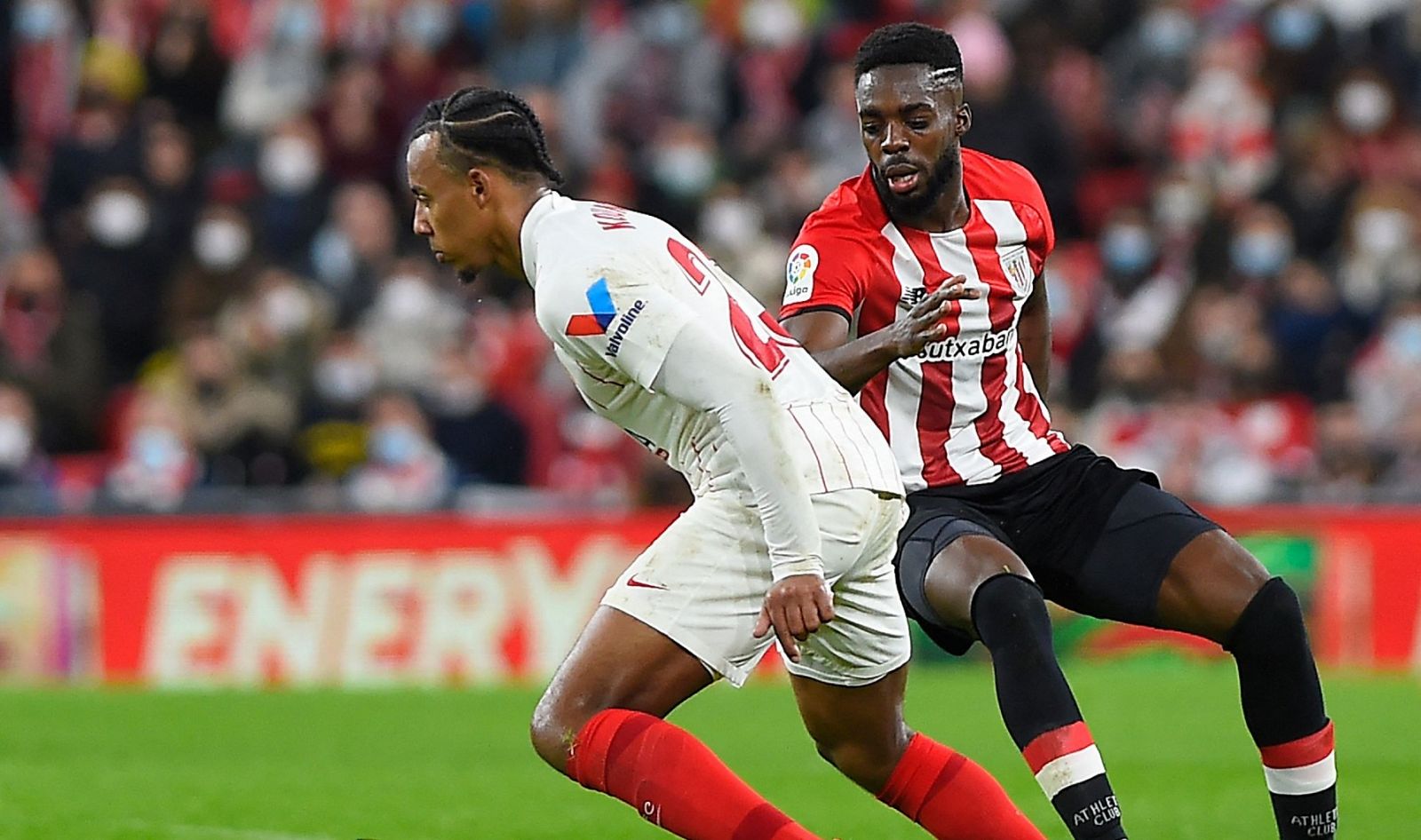 El sevillista Jules Kounde (i) y el jugadorf del Athletic Iñaki Williams (d) durante el partido de San Mamés.