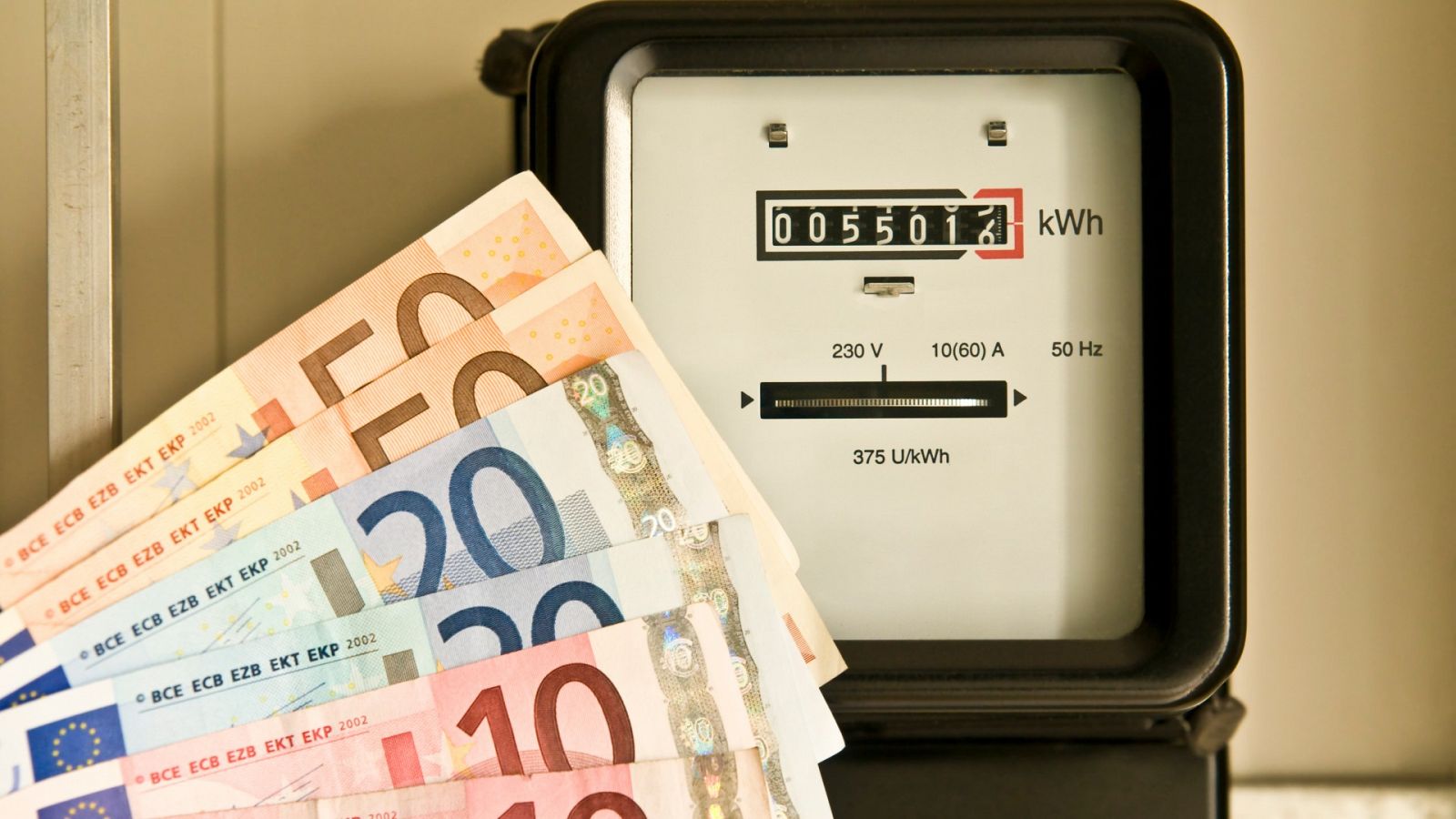 Un contador eléctrico junto a billetes de euro