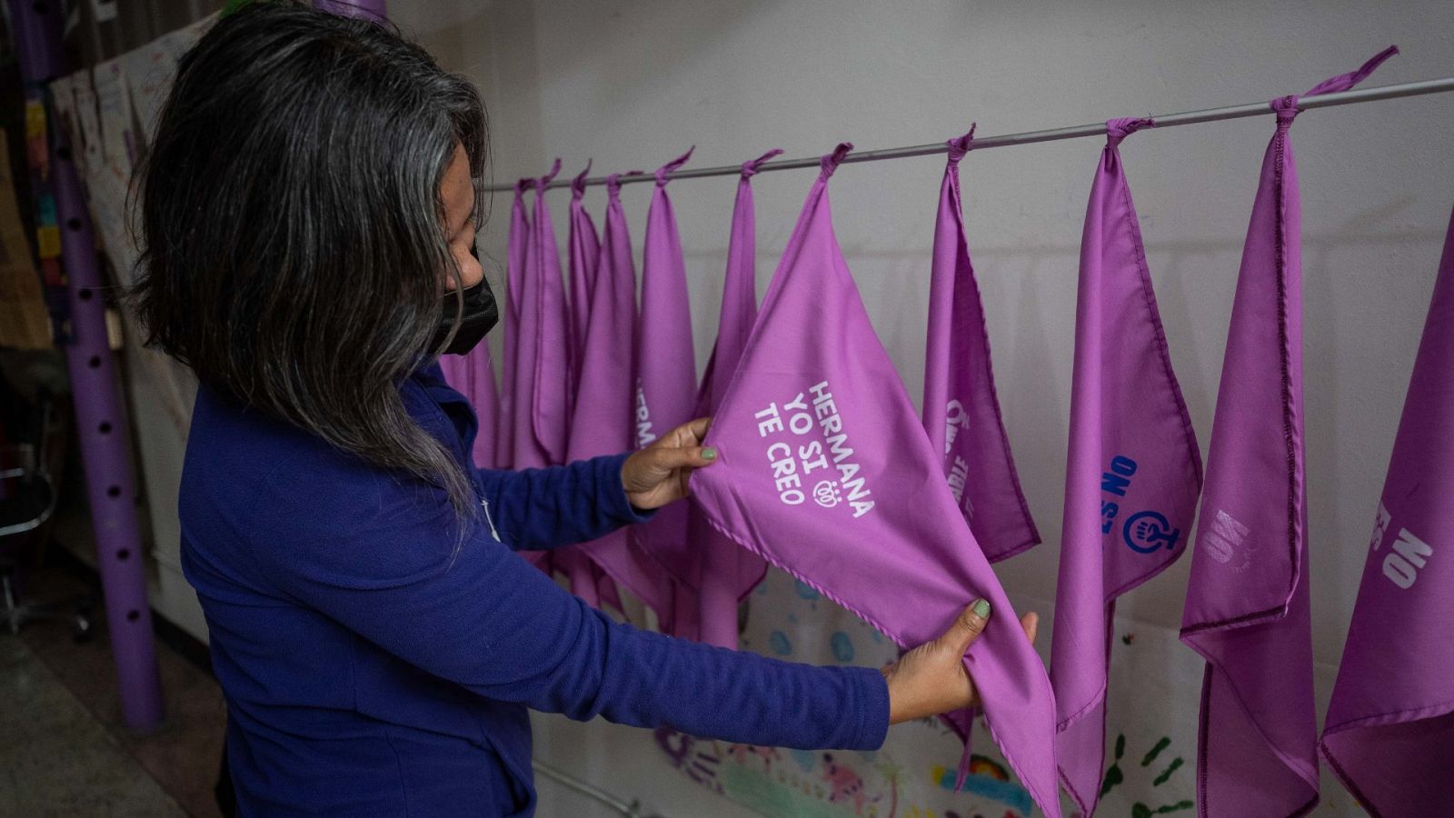 Una integrante del colectivo feminista Tinta Violeta muestra una pañoleta que dice "hermana yo sí te creo",