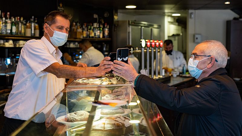 Un camarero escanea el código QR del certificado de vacunación en Barcelona. EFE/Enric Fontcuberta