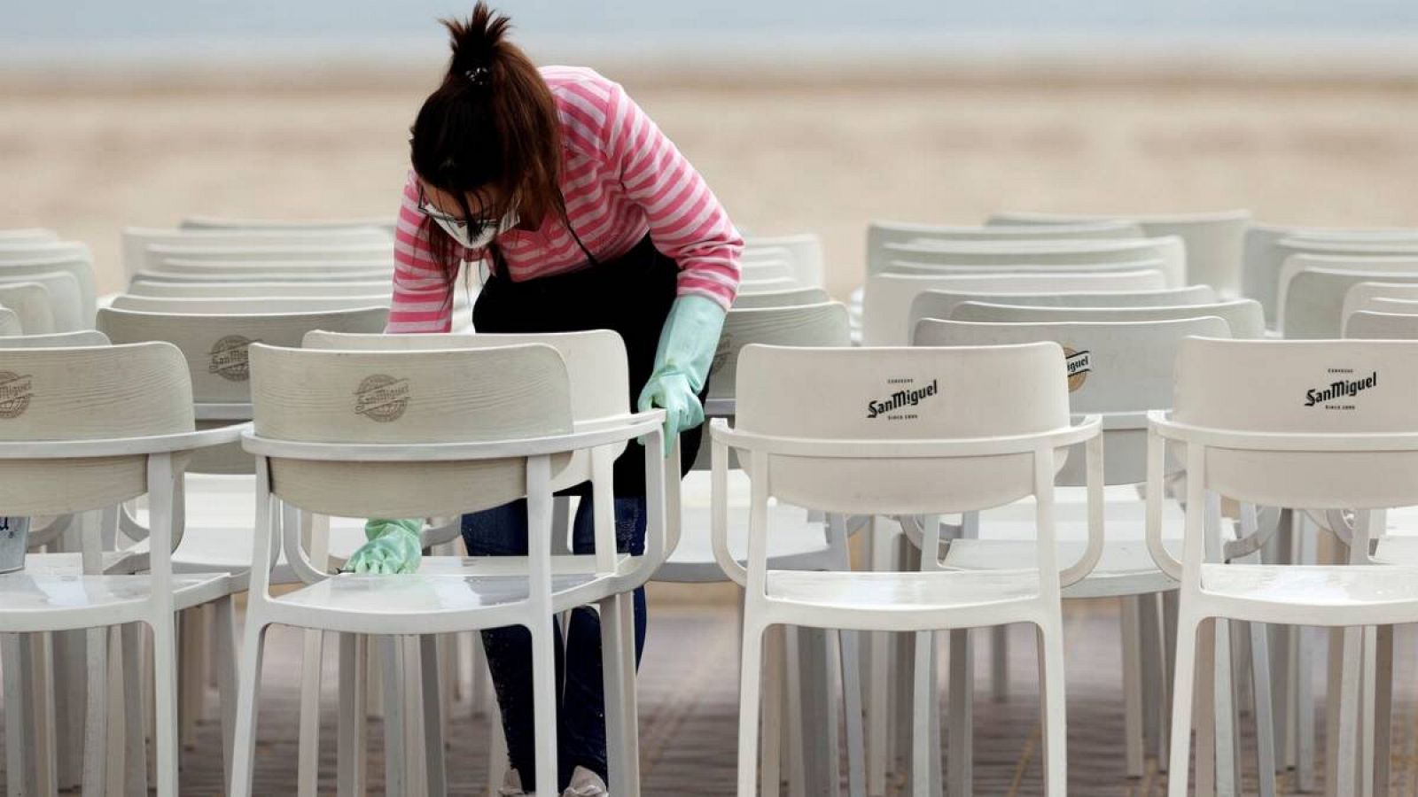 Una hostelera aprovecha la tranquilidad de la mañana del día de Nochebuena para limpiar las sillas de un restaurante en Valencia. 