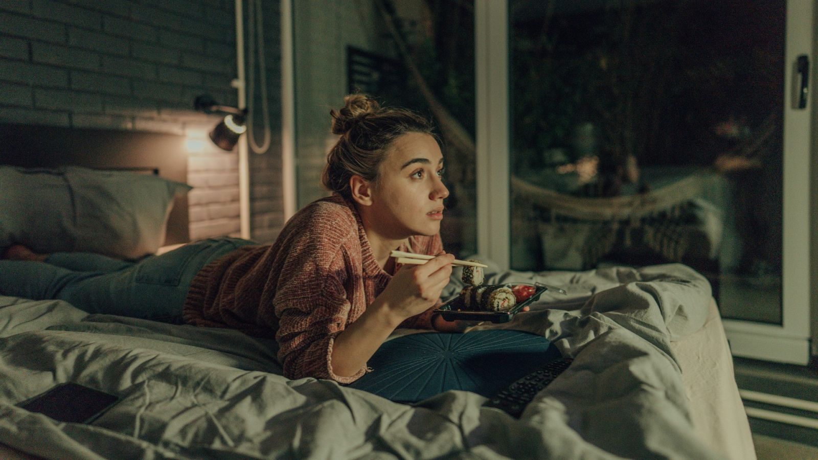 Una mujer cenando en la cama en una imagen de archivo