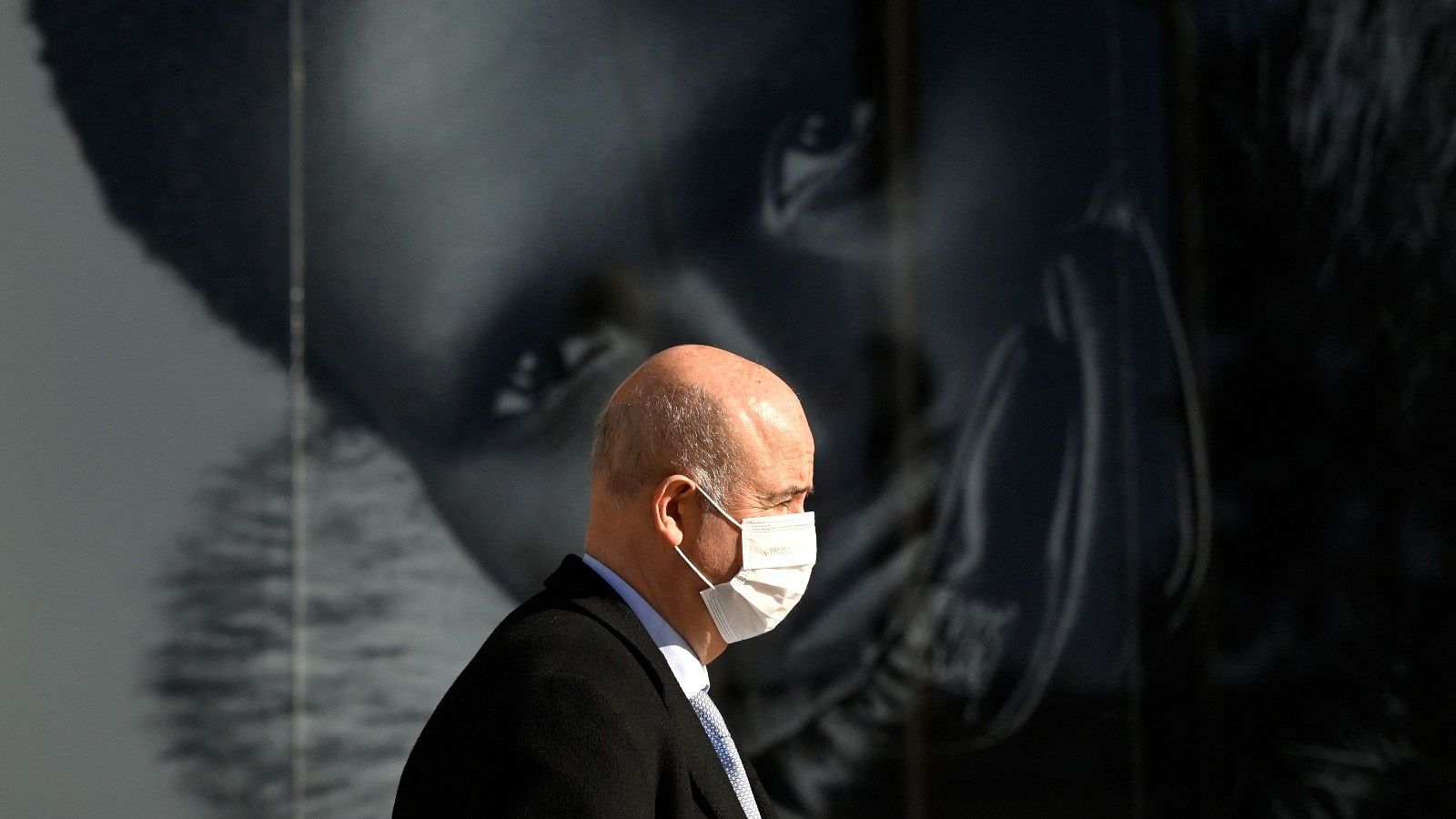 Un hombre pasea por Madrid con mascarilla