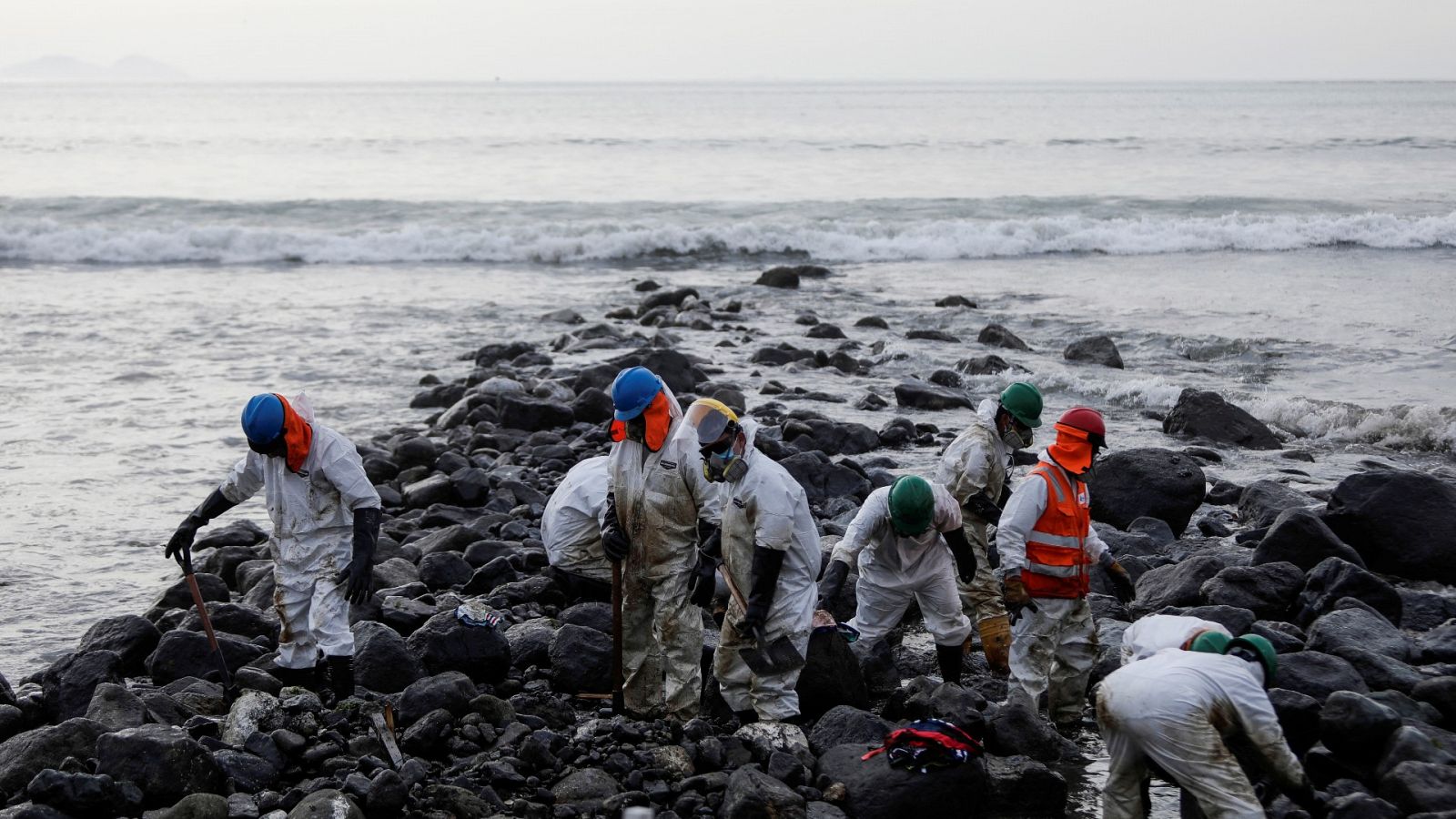 Tareas de limpieza en una playa cercana a la refinería de Repsol La Pampilla