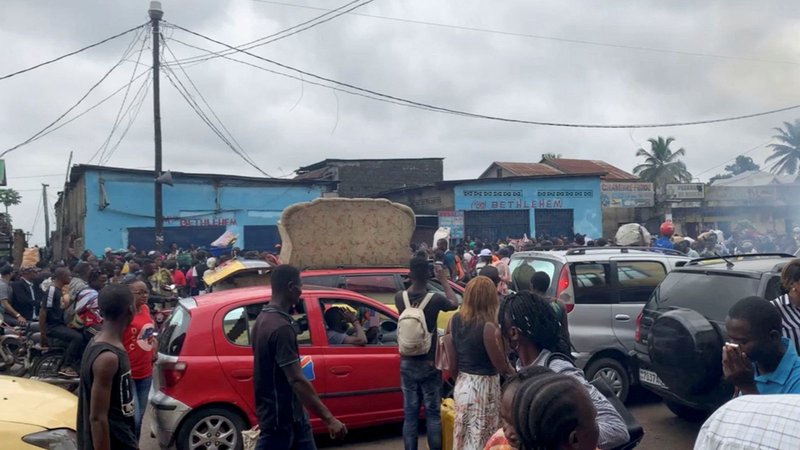 La gente camina cerca del mercado en el que la rotura de un cable de alta tensión ha acabado con la vida de 26 personas en las afueras de Kinshasa