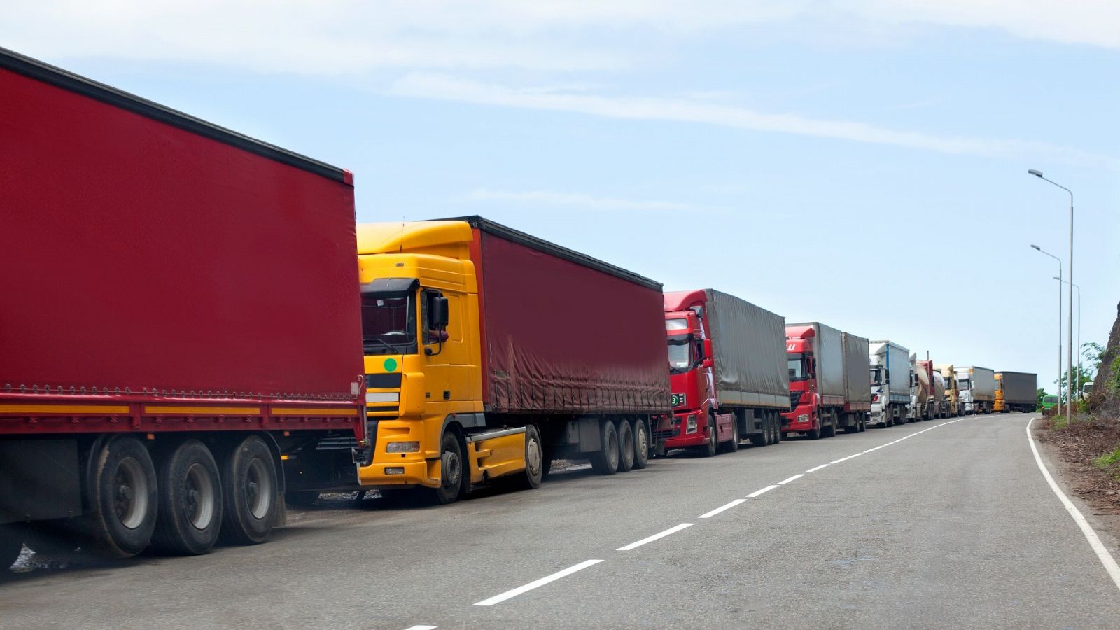 Una fila de camiones contenedores en la carretera