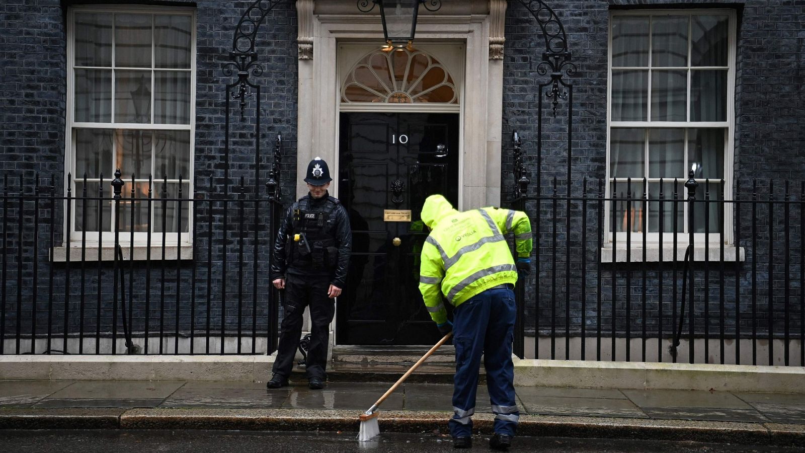 Un trabajador limpia la calle frente al número 10 de Downing Street, la residencia oficial del primer ministro británico