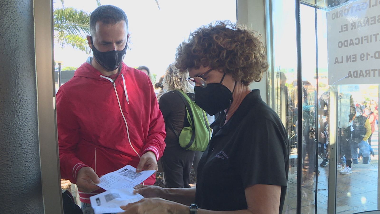 Un home mostra el seu passaport covid abans d'entrar a un restaurant