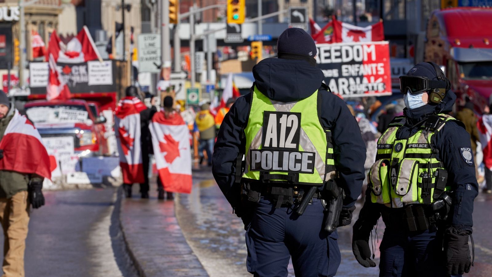 Policías vigilan a los manifestantes cerca del Parlamento en Ottawa, Ontario, Canadá