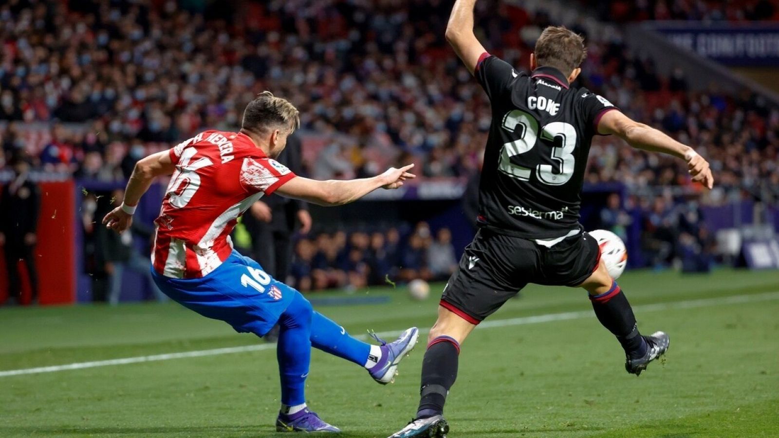 El centrocampista del Atlético de Madrid Héctor Herrera (i) juega un balón ante Coke Andújar, del Levante.