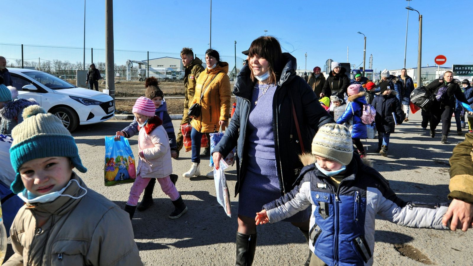 Residentes de la autoproclamada República Popular de Donetsk, la mayoría niños,  cruzan la frontera entre Rusia y Ucrania