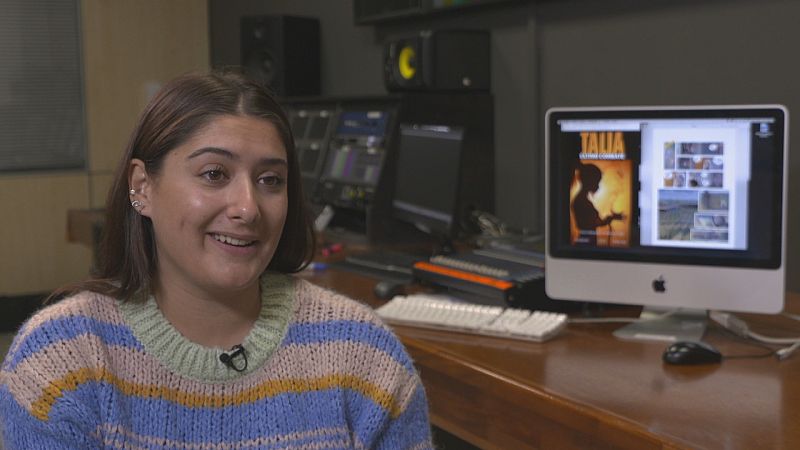 Plano medio de Ina, en un estudio de cine. Ina lleva un jersey de rayas de colores y está sonriendo.