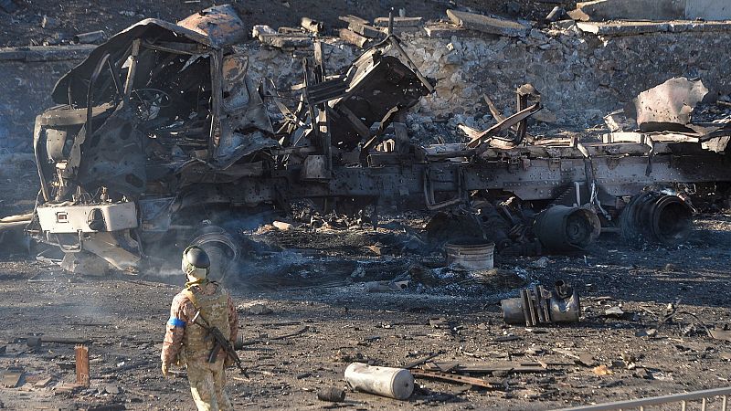 Un militar ucraniano junto a un vehículo calcinado tras los combates nocturnos en Kiev