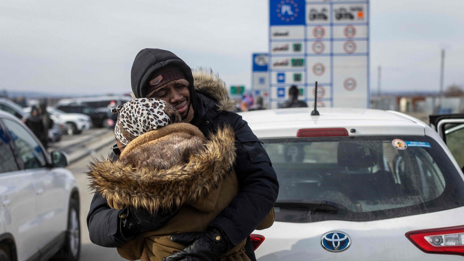 Dos refugiados se abrazan tras llegar a la frontera con Polonia