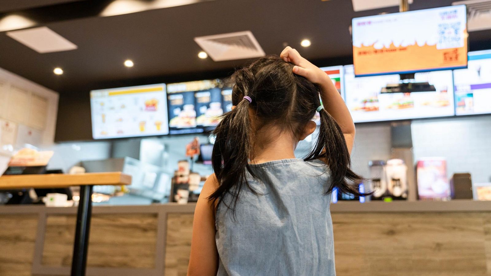 Niña en un establecimiento de comida rápida