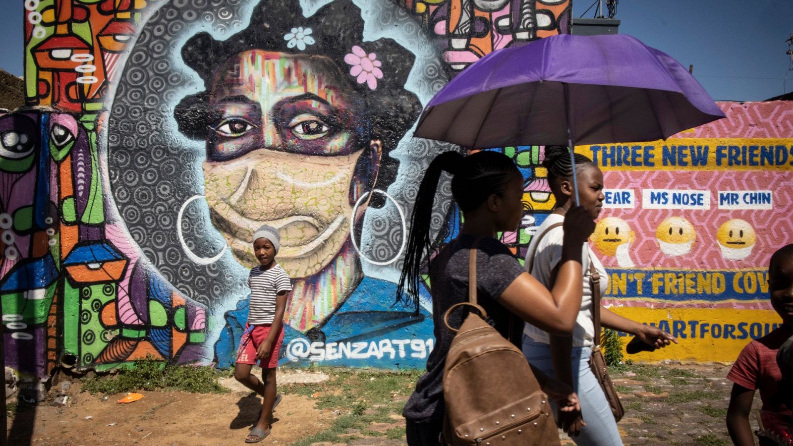 Varias personas pasan por delante de un grafiti en Johannesburgo, Sudáfrica, el 30 de noviembre de 2021. 