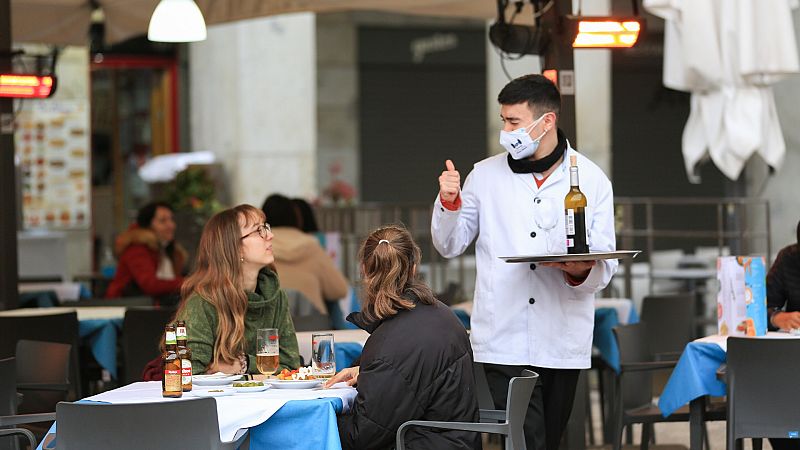 Un camarero atiende a dos clientas