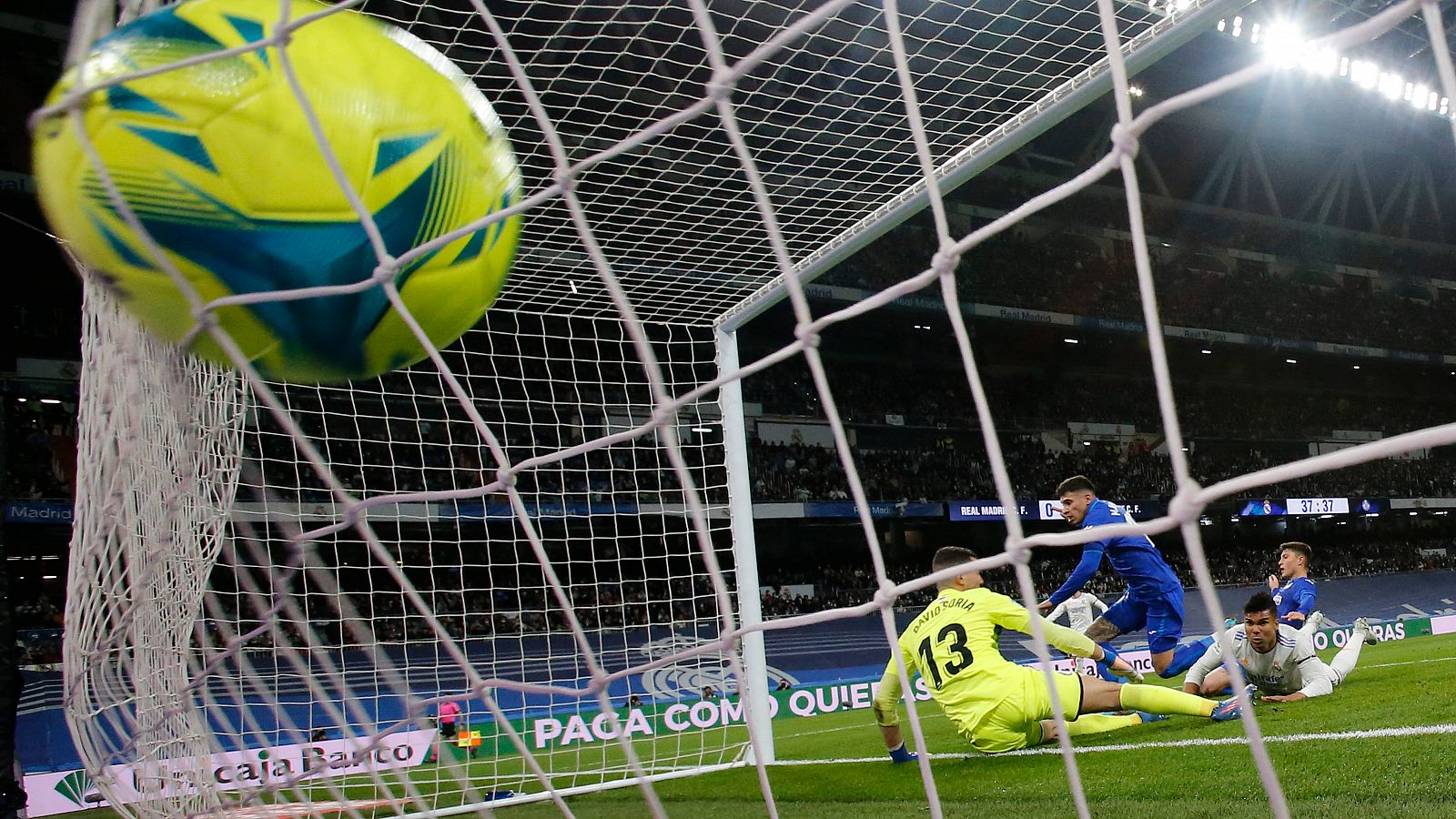 Momento del gol marcado por Casemiro (d), visto tras la red de la portería de David Soria, en el Real Madrid-Getafe