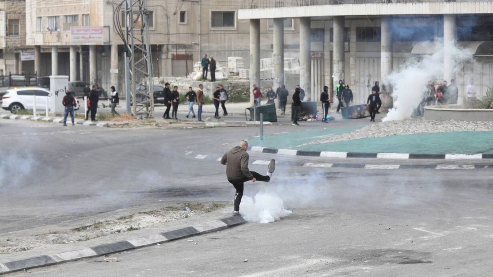 Un palestino patea una granada de gas lacrimogeno durante un enfrentamiento con las tropas israelíes en la ciudad cisjordana de Nablus, Palestina.