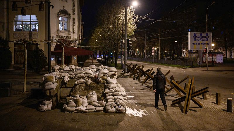 Un peatón camina por una calle entre protectores antitanque en Dnipro, Ucrania. 