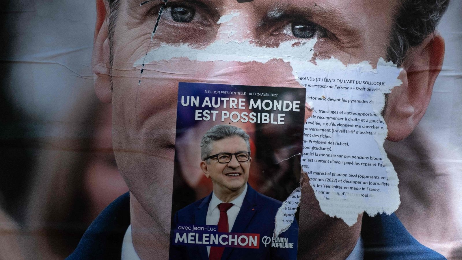 Un cartel de campaña de Emmanuel Macron cubierto con una pegatina del candidato presidencial de Jean-Luc Mélenchon