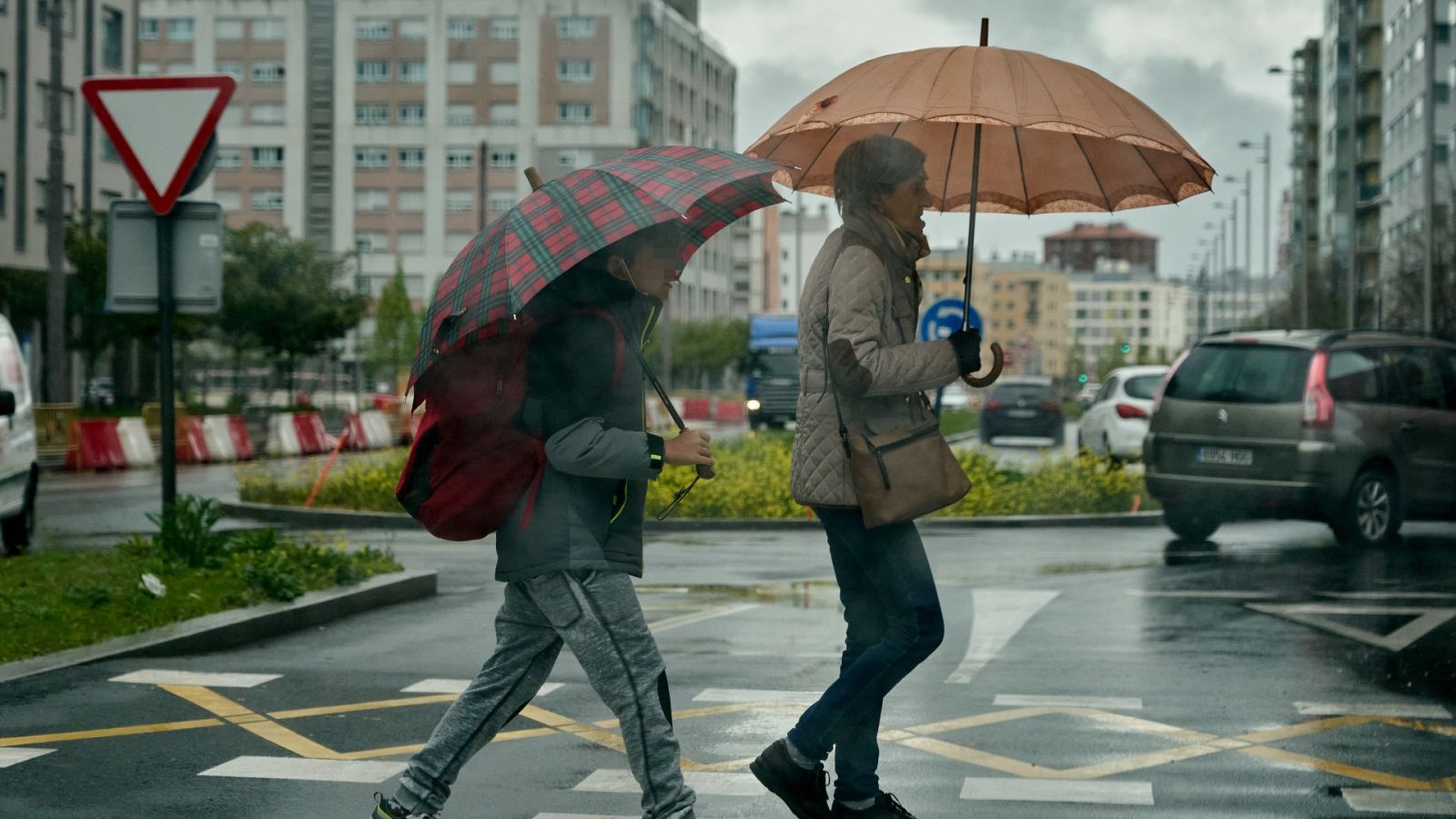 Vecinos del barrio de Salburua en Vitoria se protegen de la lluvia