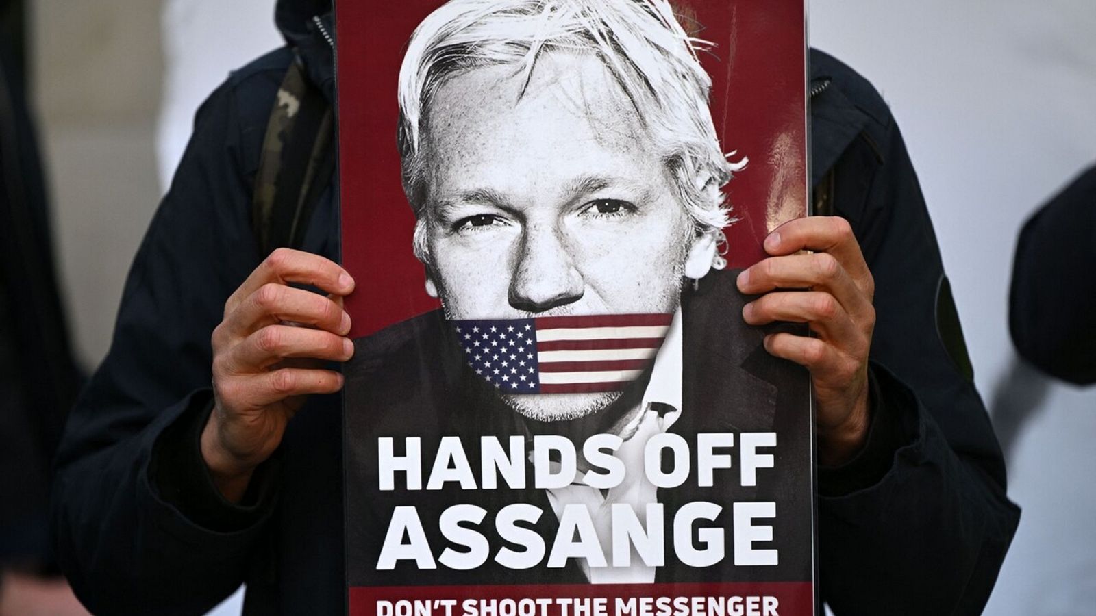 Activista con un cartel de apoyo al fundador de Wikileaks, Julian Assange. Foto: JUSTIN TALLIS / AFP