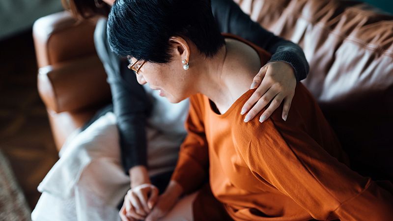 Una mujer con dolores intenta reincorporarse con ayuda de otra mujer, en una imagen de archivo