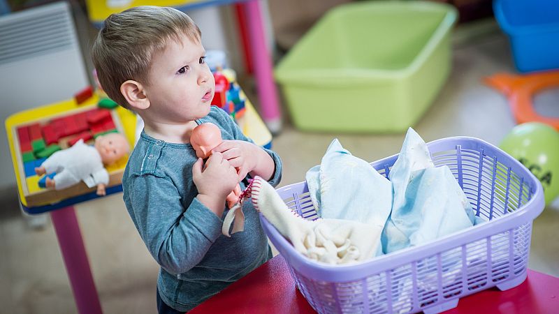 Un niño juega con un bebé de juguete.