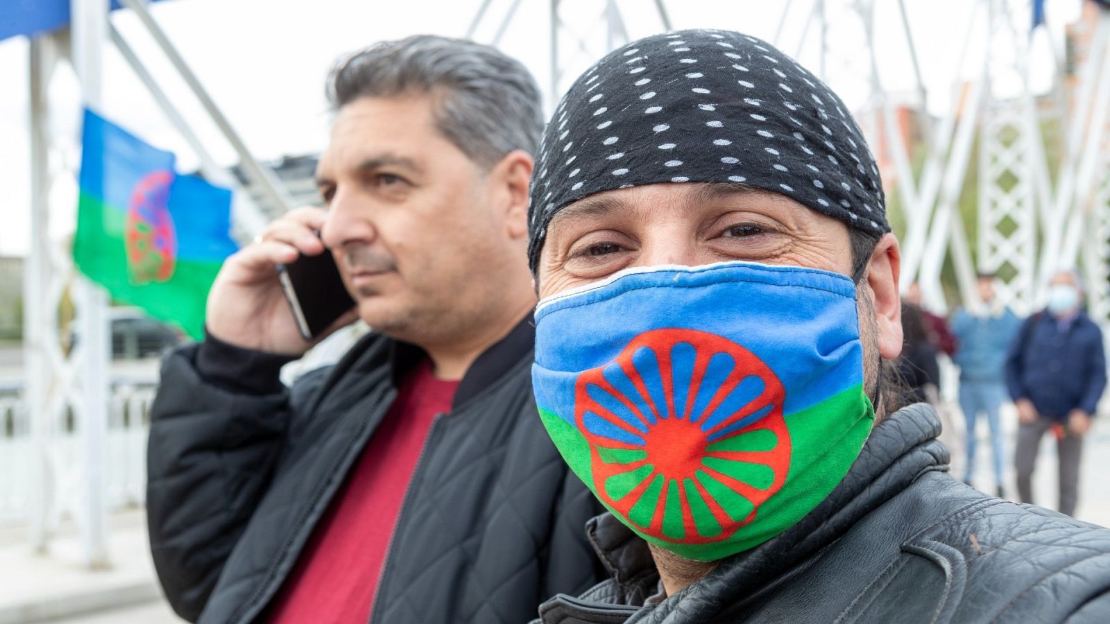 Un hombre con una mascarilla con la bandera del Pueblo Gitano